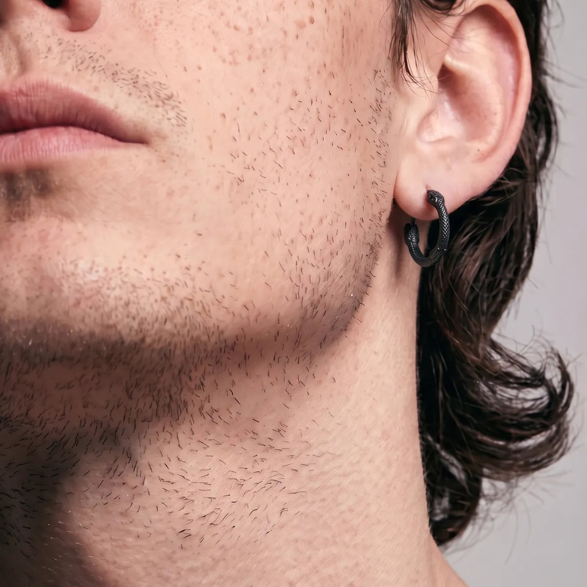 Black Double Snake Head Hoop Earrings Worn by Male Model Close Up