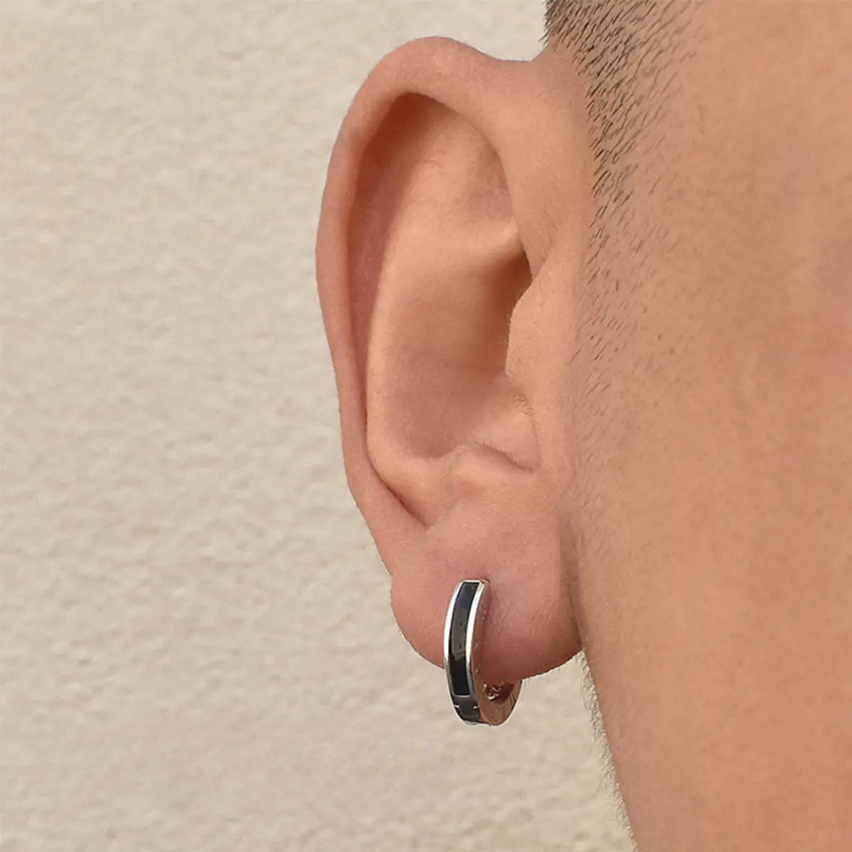 Black Roman Numeral Stud Earrings Worn by Male Model Front View