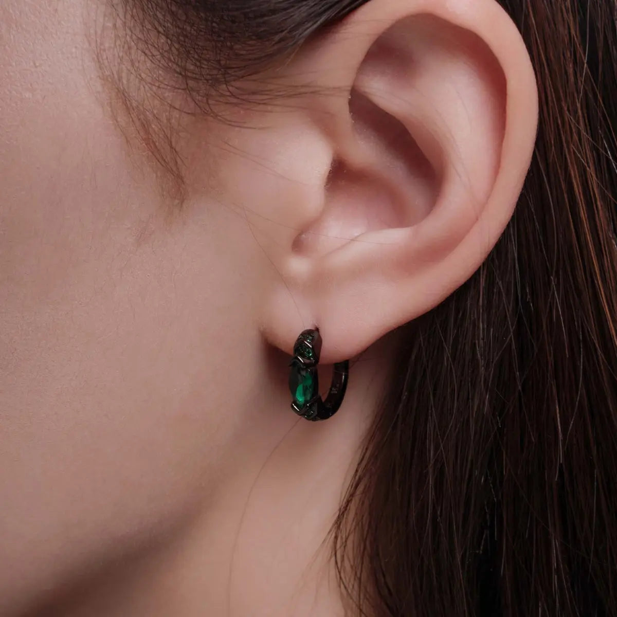 Eye of Horus Hoop Earrings Emerald CZ Worn by Female Model Close up