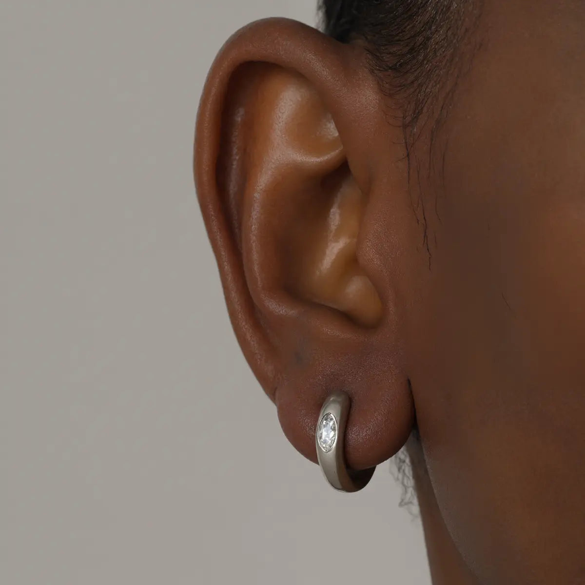 Eye of Horus Huggie Hoop Earrings White Gold 4mm Worn by Male Model Close Up