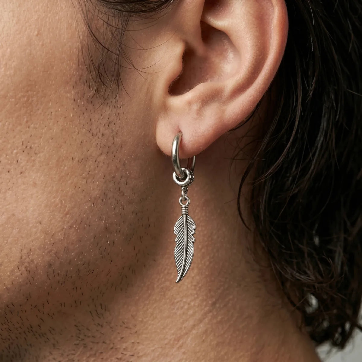 Feather Charm Earrings Silver Worn by Male Model Close Up