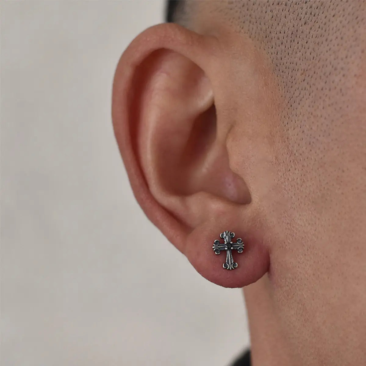 Fleur de Lis Cross Stud Earrings Worn by Male Model Close Up