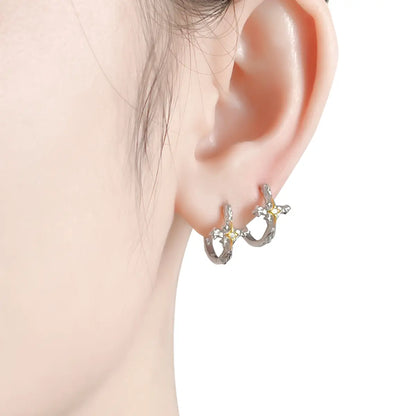 Four Pointed Star Cross Hoop Earrings Worn by Female Model
