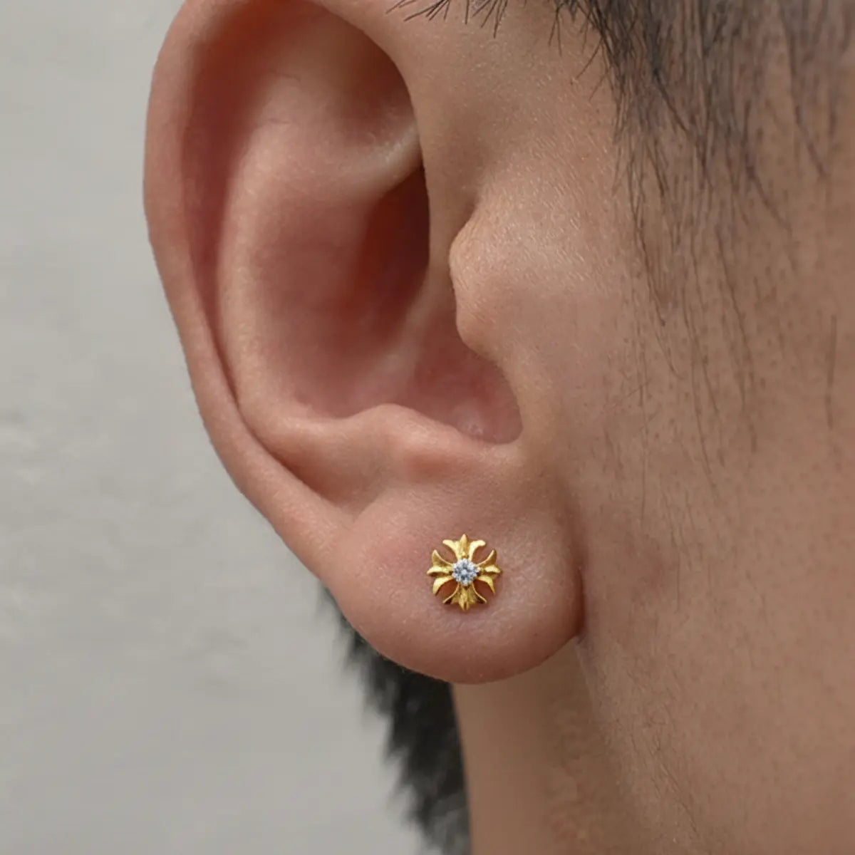 Gold Petal Cross Stud Earrings Worn by Male Model Front
