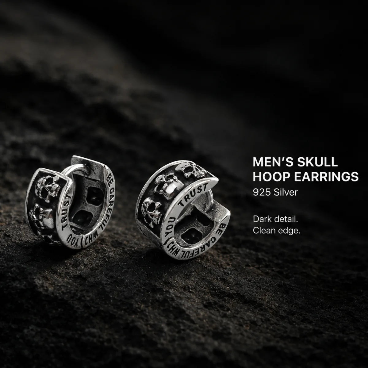 Men's Silver Skull Huggie Hoop Earrings Displayed on Stone Surface