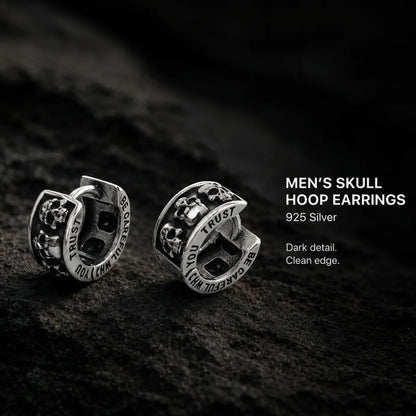 Men's Silver Skull Huggie Hoop Earrings Displayed on Stone Surface