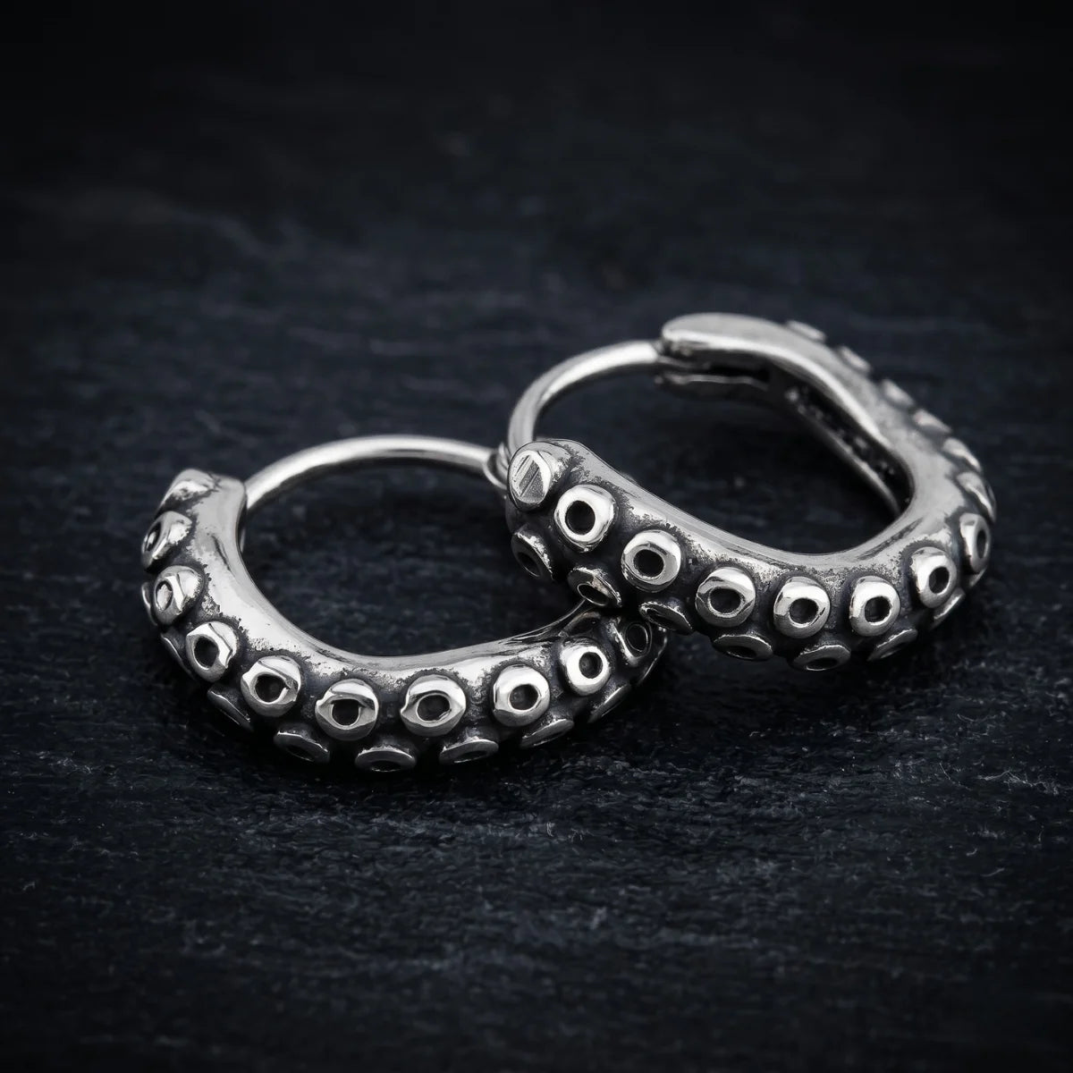 Octopus Tentacle Hoop Earrings Close Up on Dark Slate Background