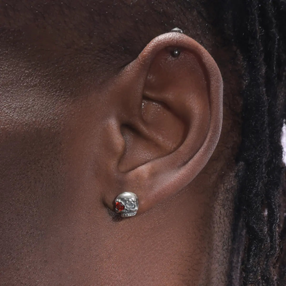 Red Eye Skull Stud Earrings Worn by Male Model