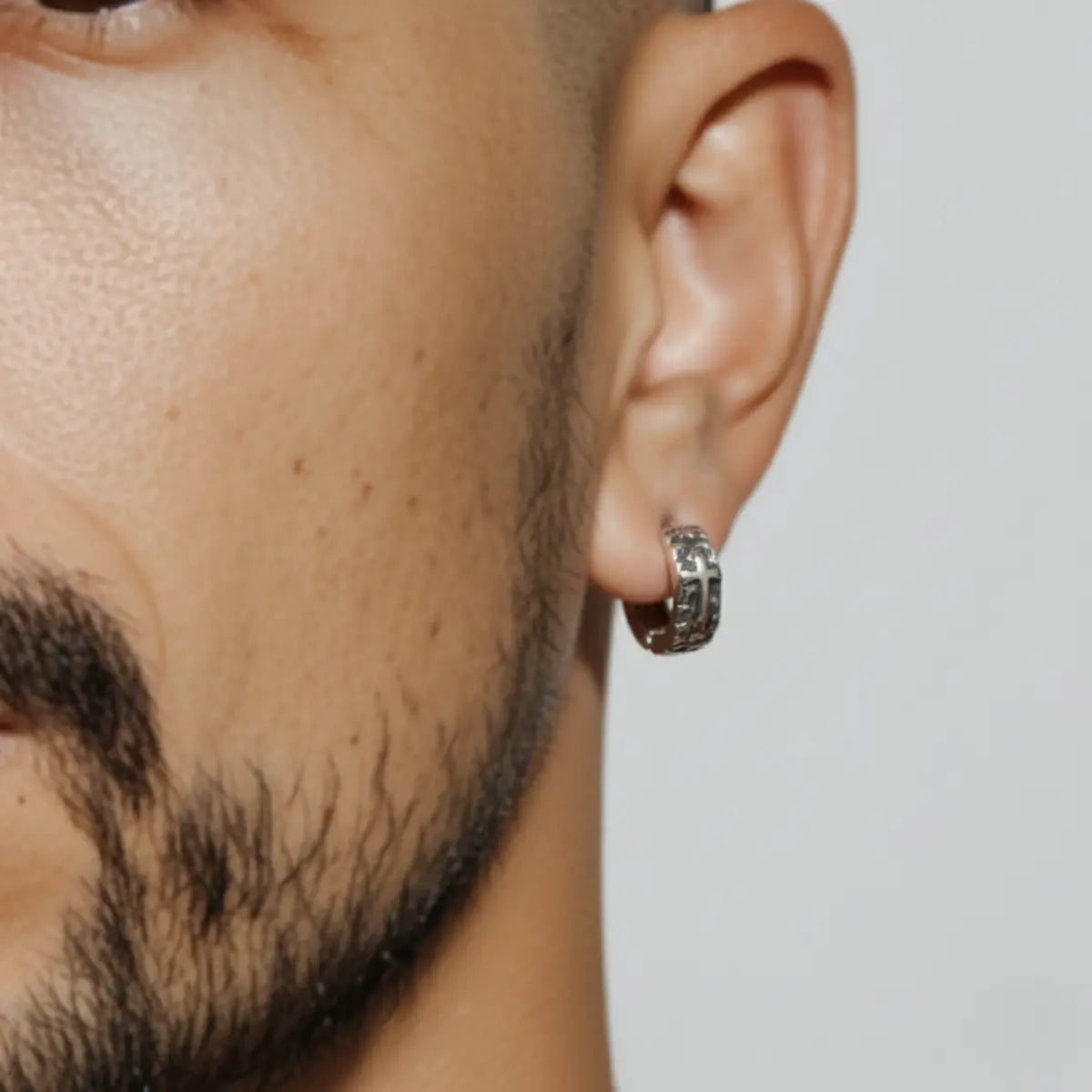 Scales Cross Huggie Hoop Earrings Worn by Male Model