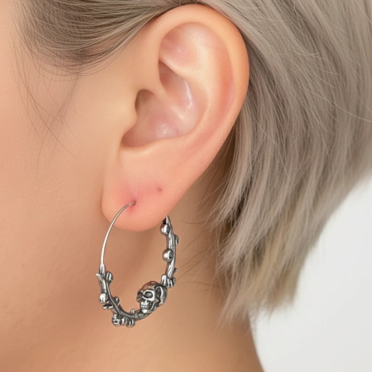 Steel Skulls on Branch Hoop Earrings Worn by Female Model Side Close Up