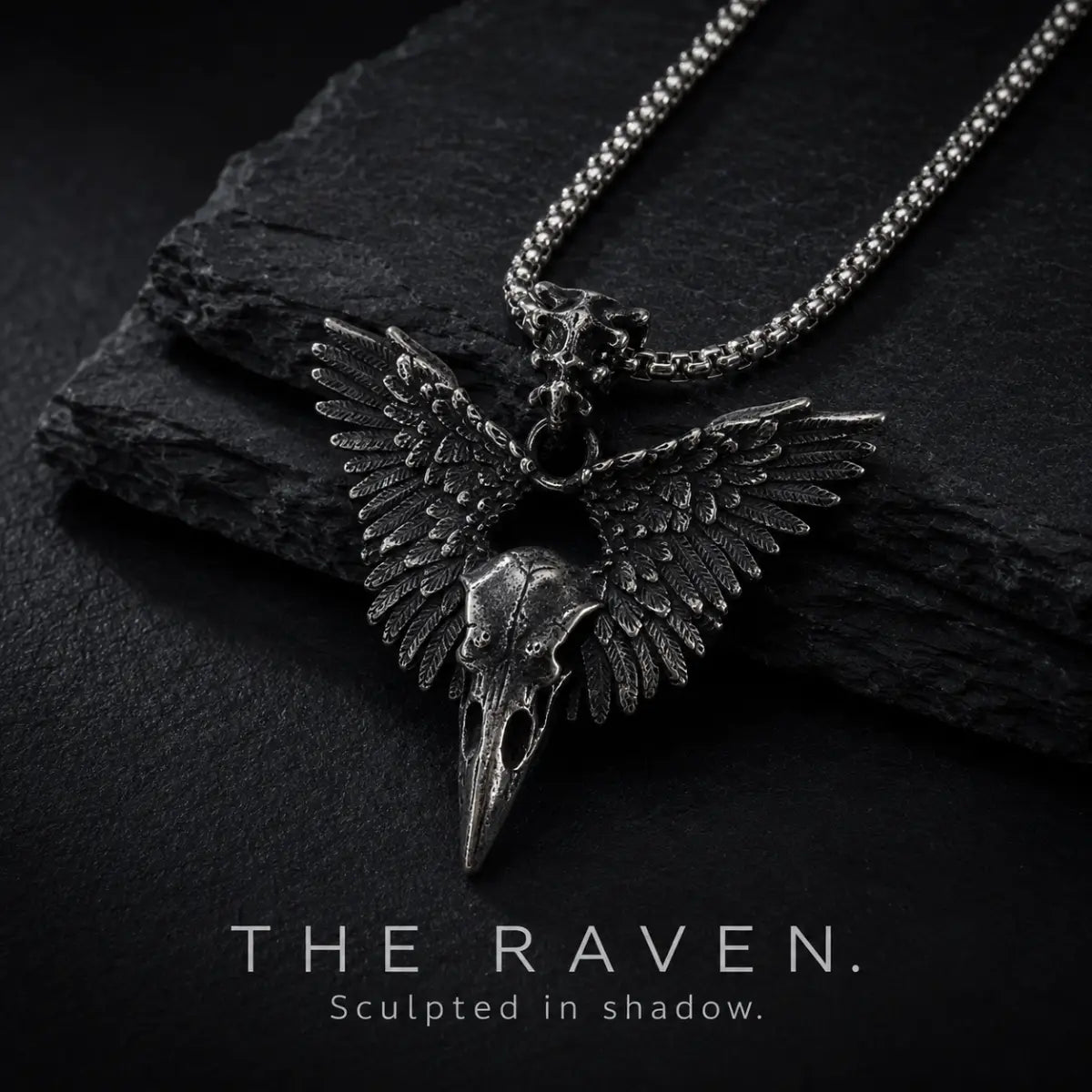 Winged Raven Skull Necklace Antique Silver Displayed on Stone Surface