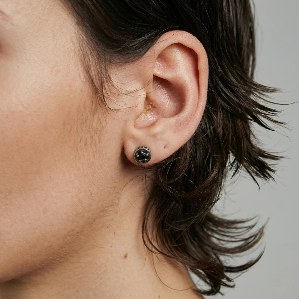 Close up of ear wearing Roman Numeral CZ Star Stud