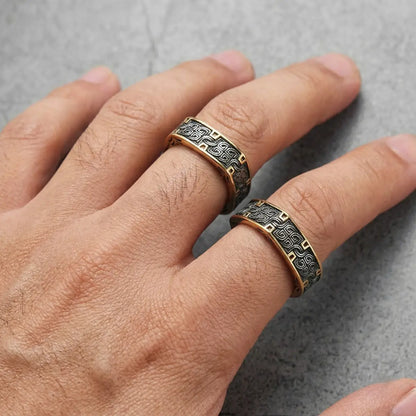 Close up of hand wearing gold Greek Key Rings