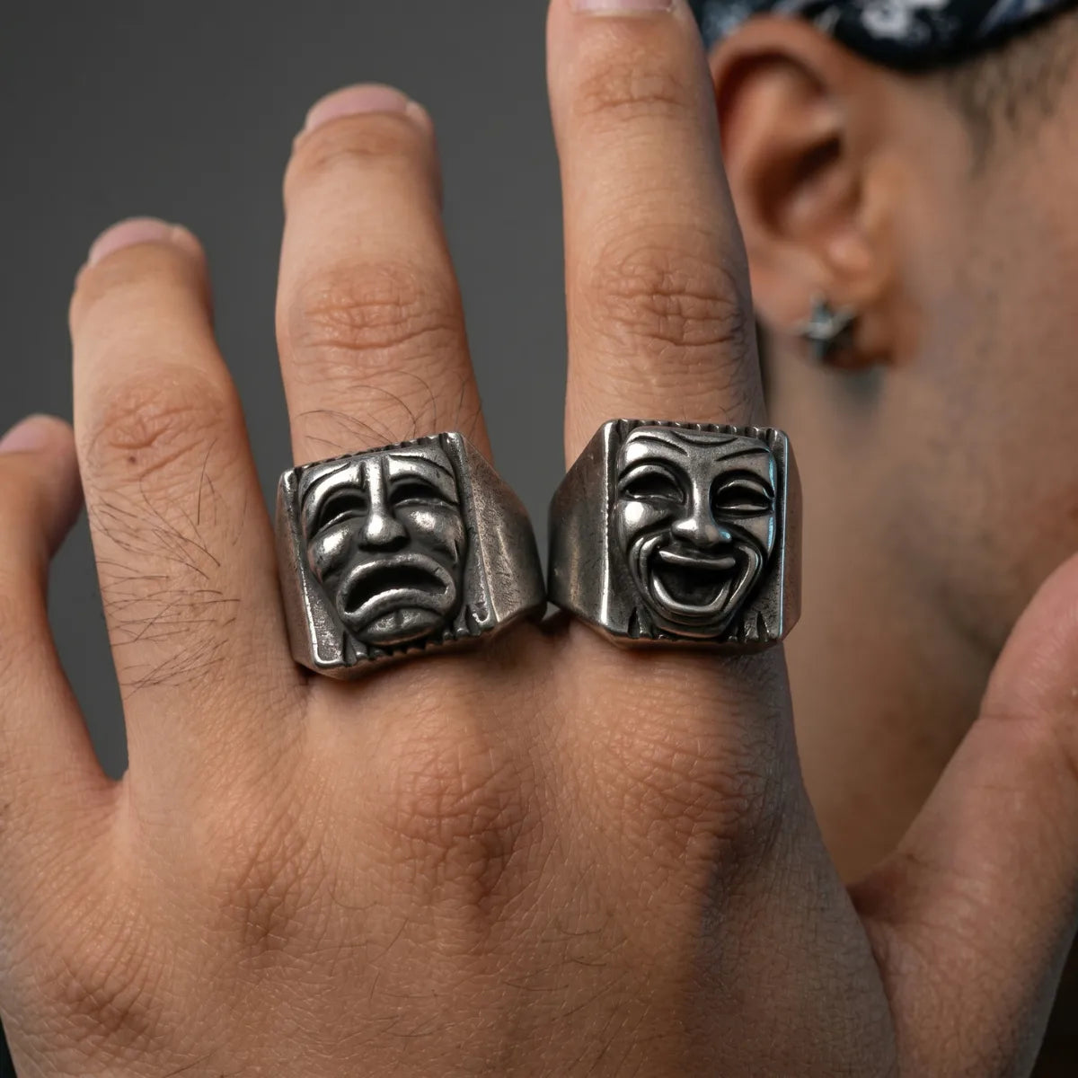 Close Up Hand Wearing Laugh Now Cry Later Rings Chicano Style Mens Jewelry