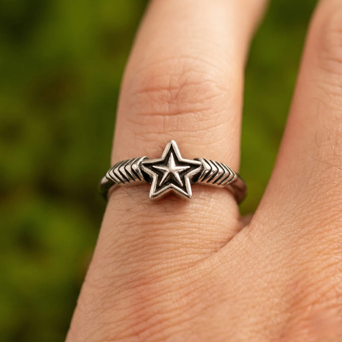 Close up Y2K star ring on finger detailed textured band