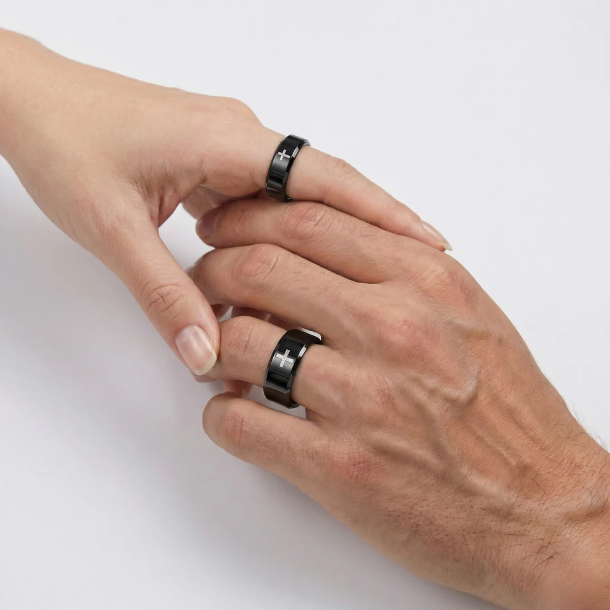 Couple holding hands wearing black Tungsten Cross Rings