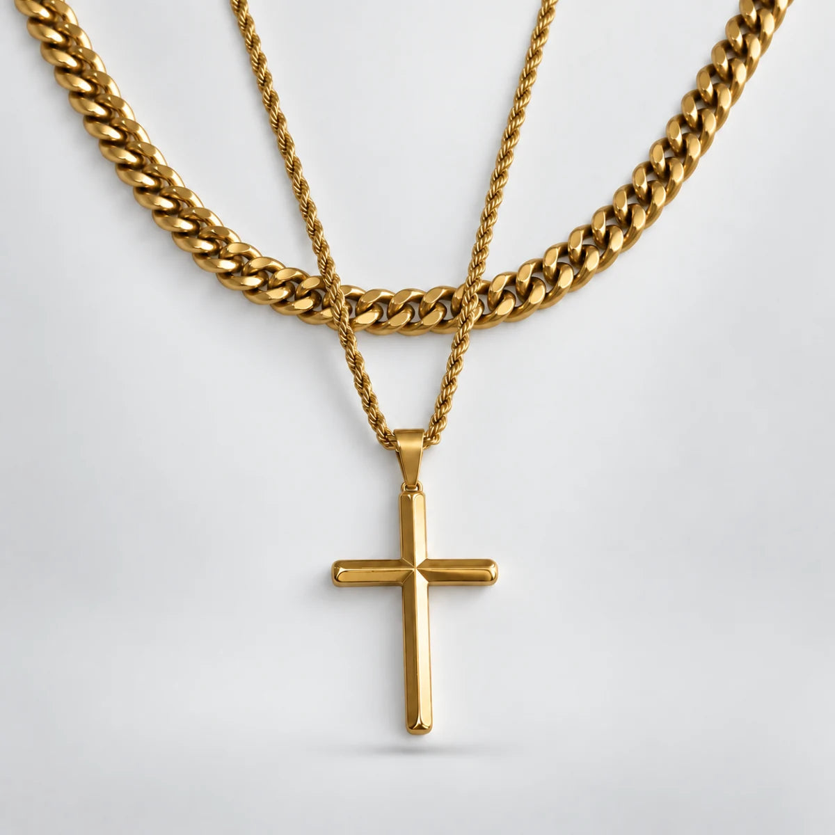 gold minimalist cross necklace layered set white background