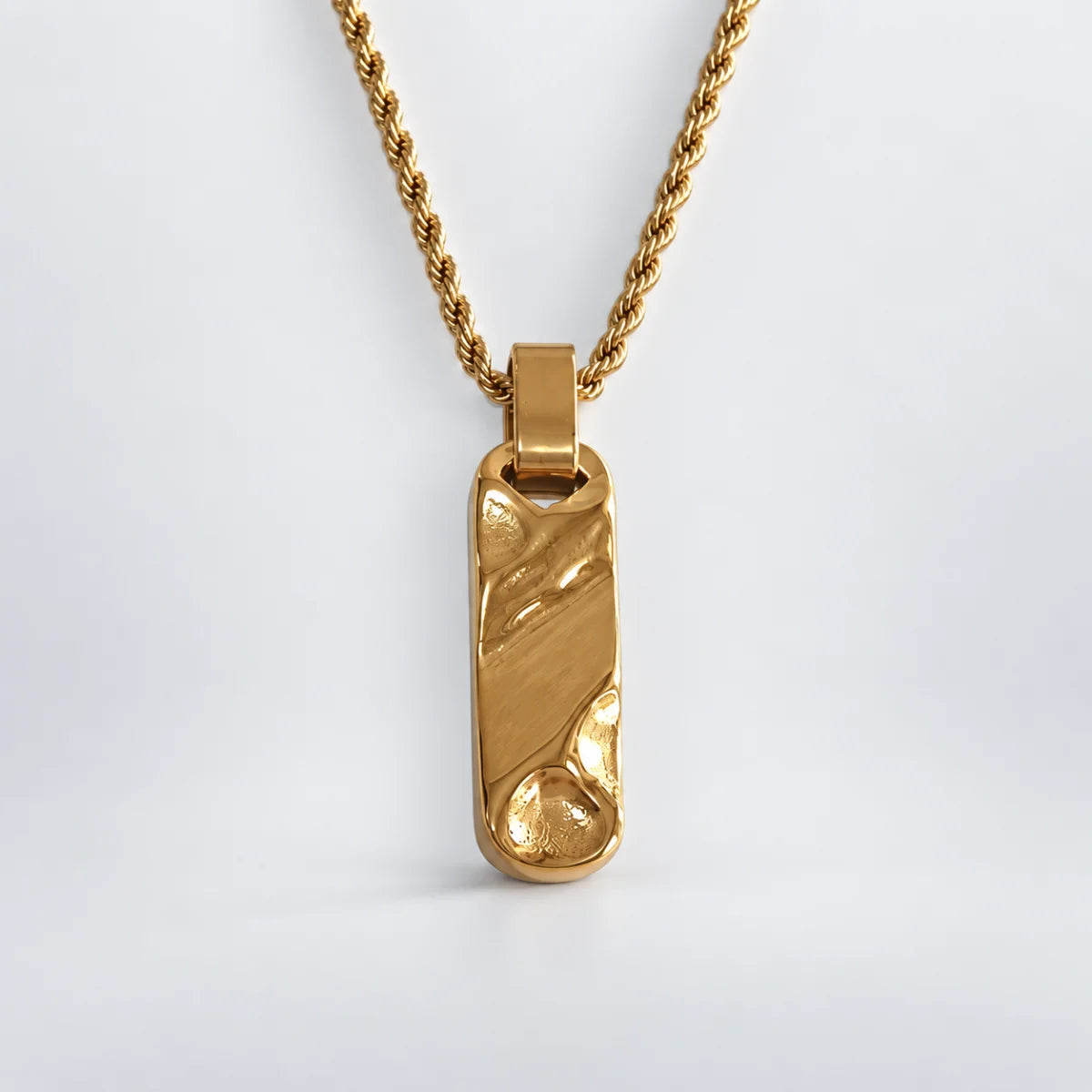 gold textured bar necklace with rope chain white background