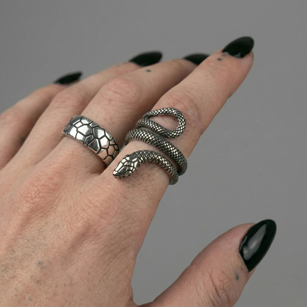 Hand wearing Shattered Snake Scale Band with coiled snake ring