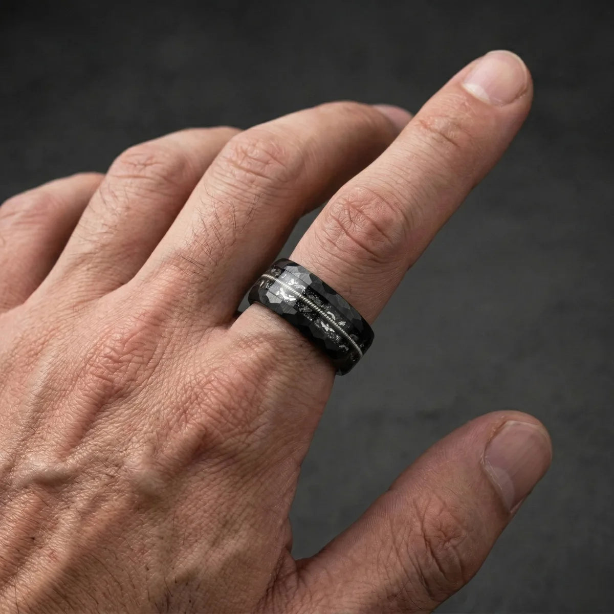 Men‘s 8mm black tungsten ring with guitar string on index finger