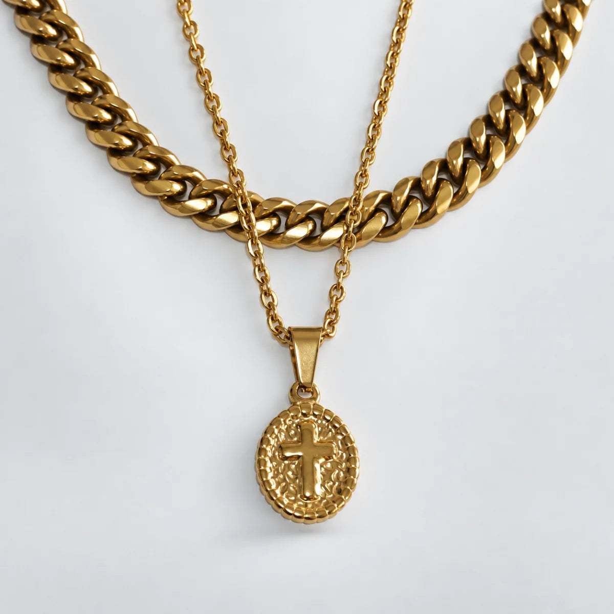 oval cross pendant necklace gold layered set white background