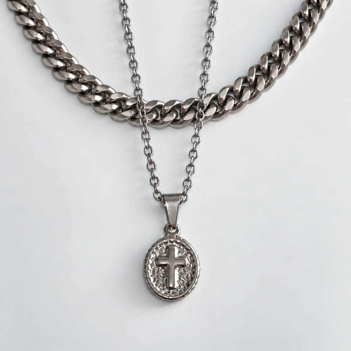 1. oval cross pendant necklace silver layered set white background