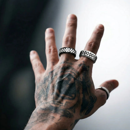 Tattooed hand wearing black and silver Checkered Spinner Bands