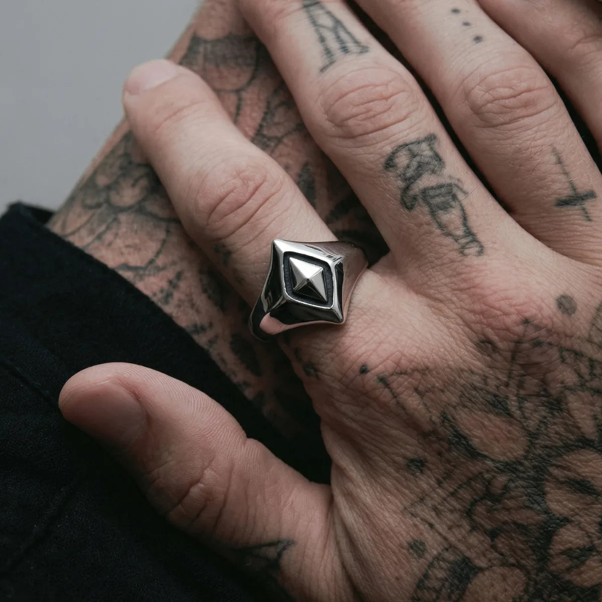 Tattooed hand wearing silver Geometric Rhombus Ring