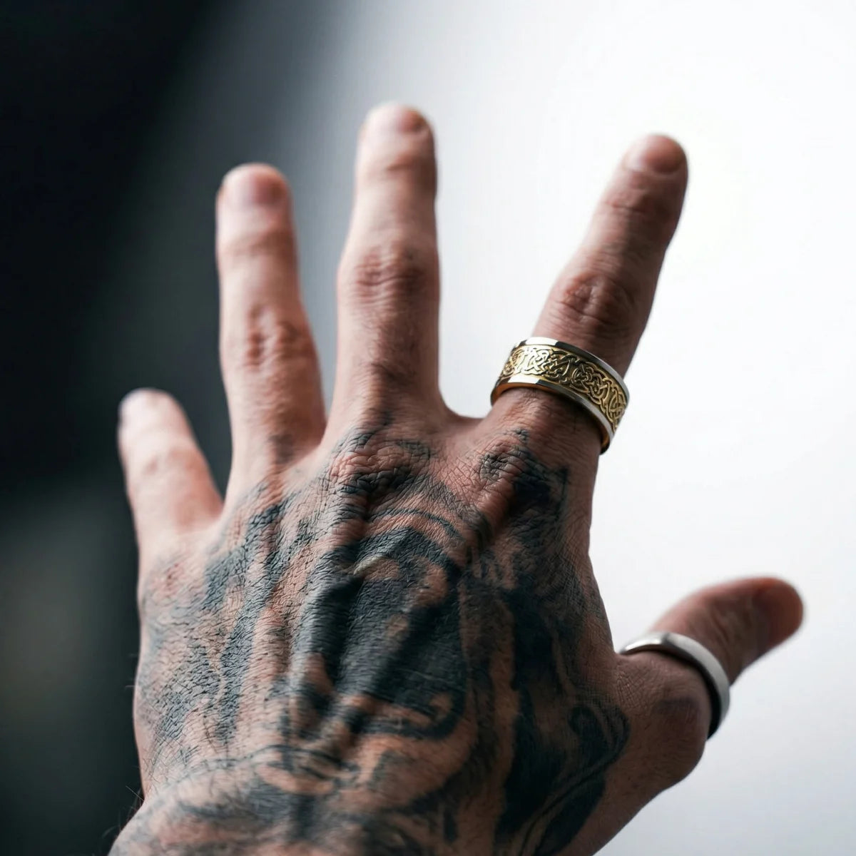 Tattooed man wearing gold Celtic Knot Band
